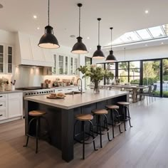 a large kitchen with an island and lots of stools