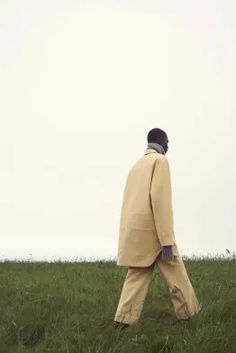 a man walking across a lush green field