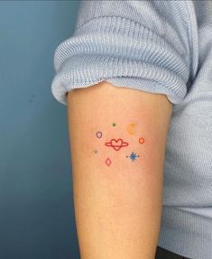 a woman with a small tattoo on her arm that has an image of the planets and stars