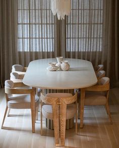 a dining room table with chairs and a chandelier hanging from it's ceiling