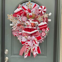 a christmas wreath with candy canes, candies and santa clause on the front door