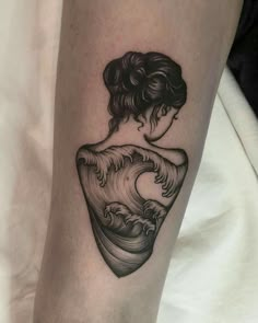 a woman's arm with a wave tattoo on it