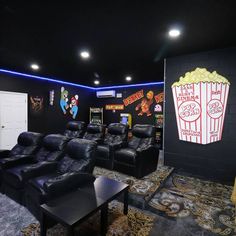 an empty movie theater with black leather chairs and popcorn buckets on the wall in front of them