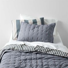 a bed with blue and white striped pillows