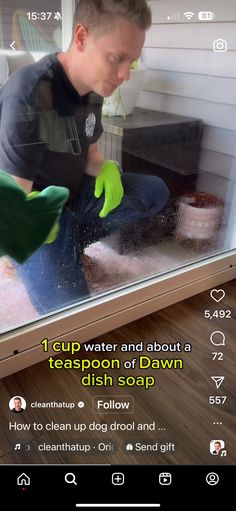 a man in green gloves is cleaning the window with his hand and gloved hands