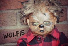 a doll with hair and green eyes is wearing a red plaid shirt that says wolfie