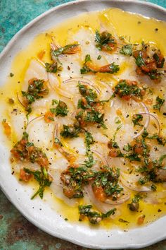 a white plate topped with lots of food on top of a blue tablecloth covered in yellow sauce