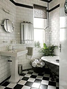 a black and white bathroom with checkered flooring, tub, sink and mirror