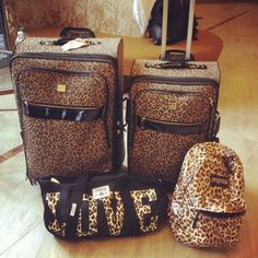 three pieces of luggage sitting on the floor in front of a wall with an animal print design