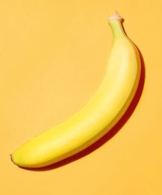 a banana sitting on top of a yellow surface