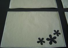 four pieces of white paper with black flowers on the edges and one piece has been cut out