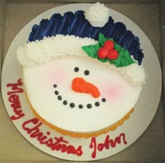 a frosted cake with a snowman's face on it