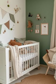 a baby's room with green walls and white furniture