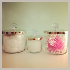 three glass jars with pink and white flowers in them