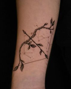 a black and white photo of a tattoo on someone's arm with vines growing out of it