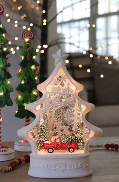 a lighted christmas tree with a red truck under it