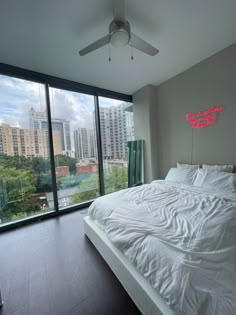 a bed sitting in a bedroom next to a large window with city lights on it