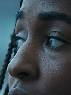 a close up of a woman's face with blue eyes