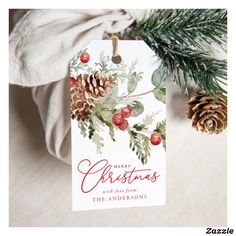 a christmas gift tag with pine cones and berries