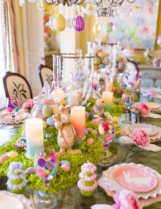 the table is set with candles, plates and other decorations for an easter dinner or brunch