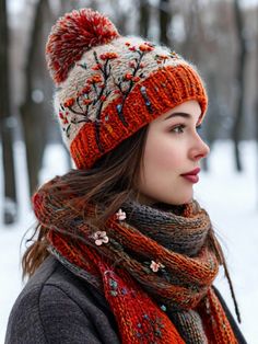 a woman wearing a knitted hat and scarf in the snow with trees behind her