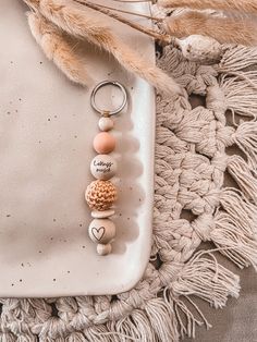 a key chain with two beads hanging from it's side on a white tray