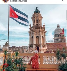 a woman is standing on a balcony with a flag flying in the air behind her