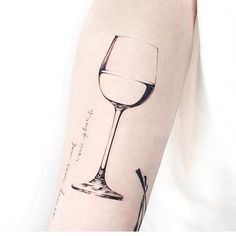 a person with a wine glass tattoo on their arm