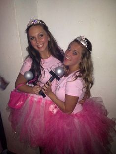 two girls dressed up in pink and wearing tiaras, posing for the camera with each other