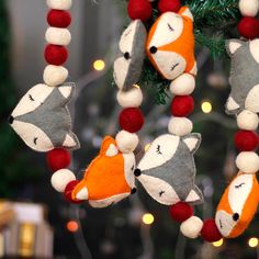 a christmas ornament hanging from a tree decorated with red, white and gray ornaments