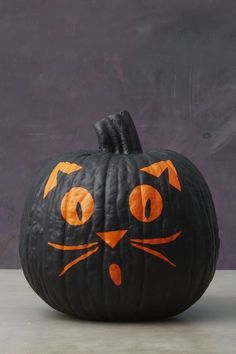 a pumpkin with an orange cat painted on it