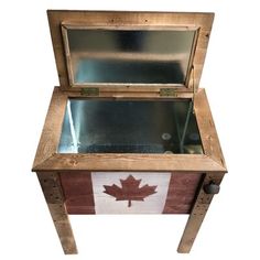 an open wooden box with a canadian flag painted on the front and bottom, sitting on two legs