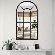 a living room filled with furniture and a large mirror on top of a fireplace mantel