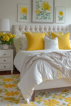 a bed with yellow and white pillows in a bedroom next to two pictures on the wall