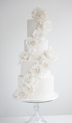 a white wedding cake with flowers on it and instagrams above the top tier