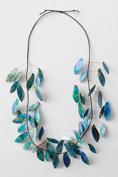 a necklace made out of blue and green leaves