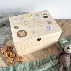 a wooden box sitting on top of a blanket next to toys