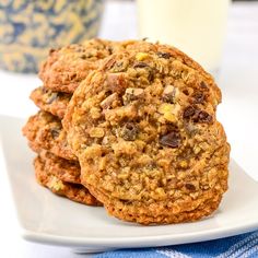 several cookies on a plate next to a glass of milk