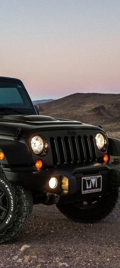 a black jeep is parked in the desert