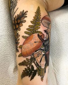 a person with a tattoo on their arm has a mushroom and leaves in the background