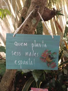 a sign hanging from the side of a tree that says quem planta seus maias espanta