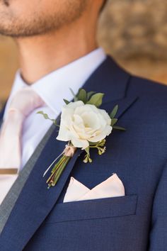 a man in a suit with a boutonniere and flower on his lapel