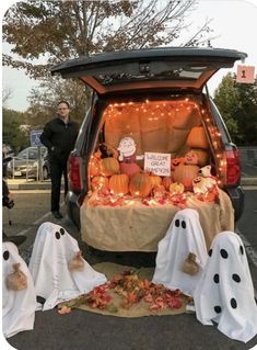 a van with pumpkins and ghost decorations in the back