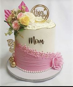 a white and pink cake with flowers on top