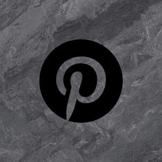 a black and white logo with the letter p in it's center on a gray marble surface