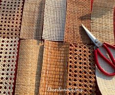 a pair of red scissors sitting on top of woven material next to some straw cloth