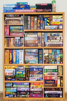 a bookshelf filled with lots of different types of games and video game consoles