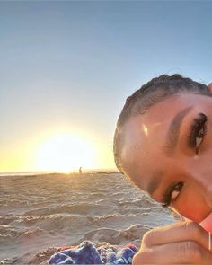 a young man is on the beach with his toothbrush in his mouth as the sun sets