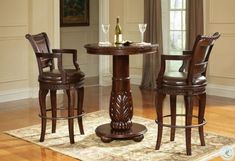 a small table with two chairs and a wine glass on it in front of a window