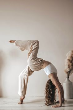 a woman is doing a handstand on the floor